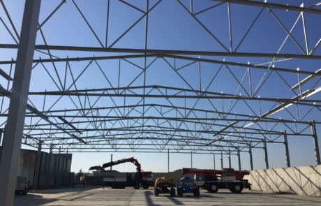 Máquinas construyendo una nave industrial, cuyos planos han sido diseñados por un estudio de arquitectura técnica.